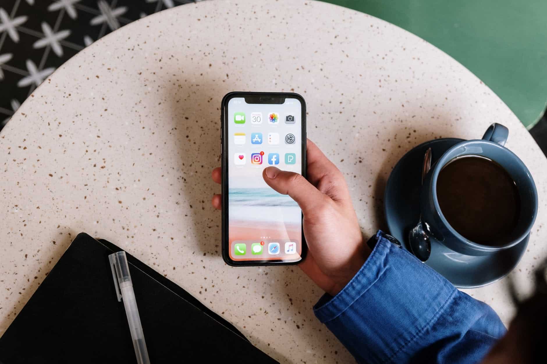 hand holding phone with social media apps